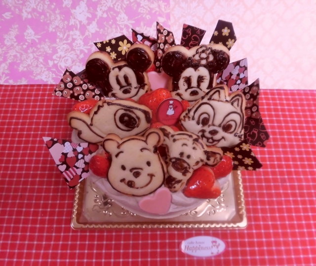 キャラクタークッキーとイチゴとチョコレートの飾りのデコレーションケーキ